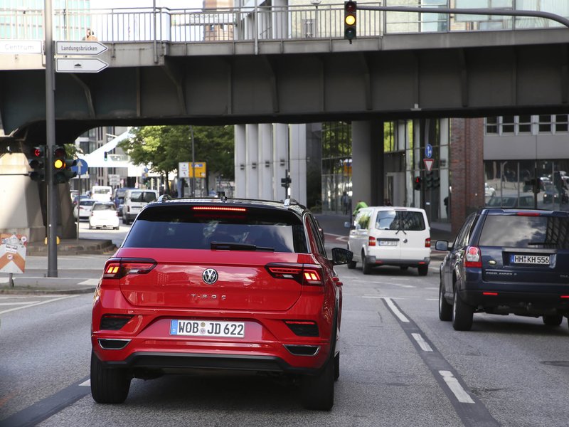freiheit-durch-auto.jpg rotes Auto, dass unter einer Brücke in der Stadt durch fährt